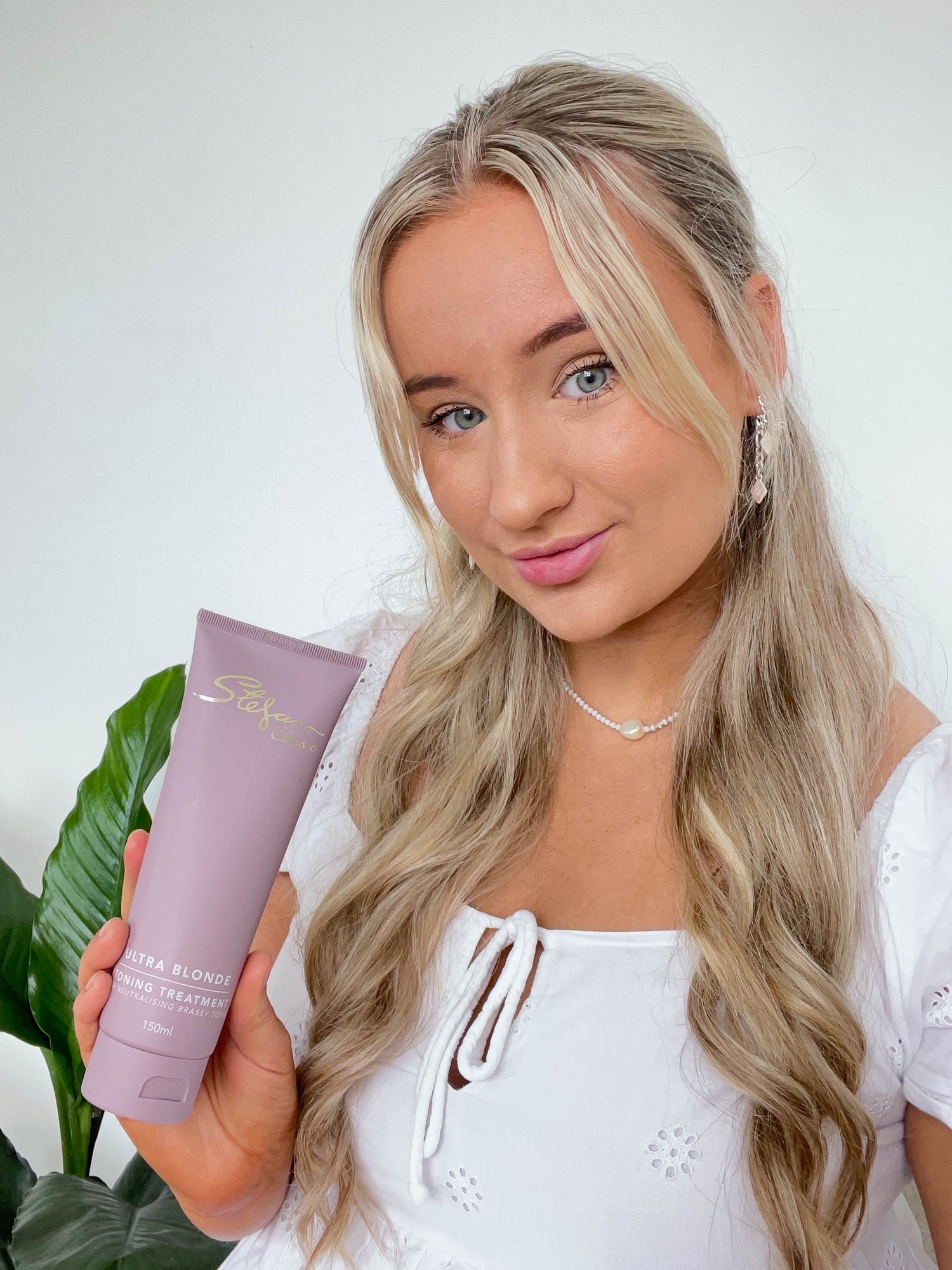 Woman holding ultra blonde toning treatment 